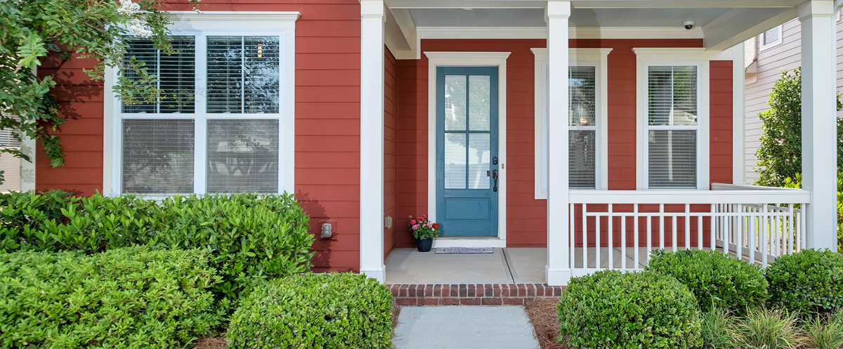 Exterior of house painted red with white trim and blue door in Jonesborough, TN